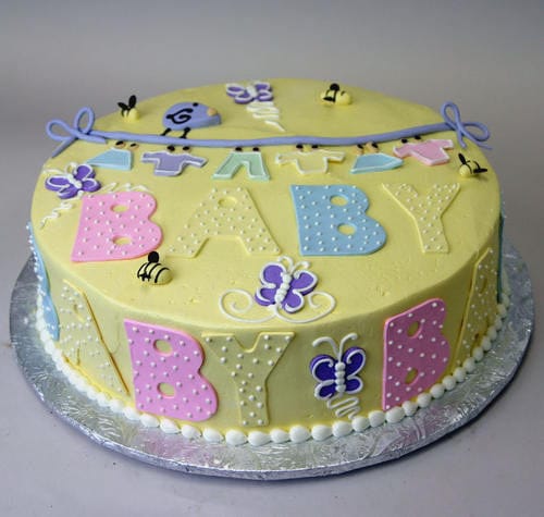 The BB-018 is a round yellow cake with pastel BABY letters, small bees, butterflies, and a purple banner, presented on a silver cake board.