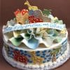 BB-033 is a round cake with colorful fondant ruffles and animal cookies—giraffes, zebras, and elephants. A ribbon on top displays “With Joy for Heidi and Nathan” in blue script.