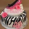 The BD-034 Zebra Shoe is a two-tier zebra-striped cake with pink roses, white flowers, a pink high heel on top, the number 40, and "Happy Birthday Daniela" in pink icing.