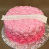 CB-018D is a round cake adorned with pink rosette frosting and topped with a white banner reading "Happy Birthday Juliana" in pink script, displayed on a silver floral-patterned cake board.