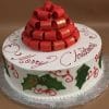 The CH-042 is a round white cake with "Merry Christmas" in red icing, green holly leaves, and a red ribbon bow topper, presented on a silver cake board.