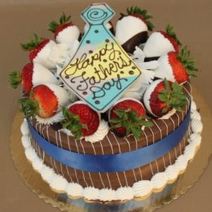 FD-005 Chocolate cake with oreo mousse filling, decorated with white and milk chocolate-dipped strawberries, white icing, a blue ribbon, and a tie-shaped cookie that says Happy Father's Day.