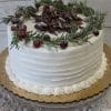 The CH-029 is a white frosted cake topped with a rosemary wreath, sugared cranberries, and chocolate shavings, presented on a gold cake board with draped white fabric.