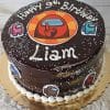 The CB-011P is a chocolate cake decorated with “Happy 9th Birthday Liam” in white icing, featuring Among Us characters and logo, and topped with white sprinkles.