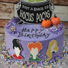 HW-018 is a purple birthday cake with sprinkles, two pumpkin toppers, a “Just a bunch of Hocus Pocus” sign, and silhouettes of three witches' heads on the side.