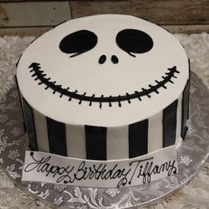 Celebrate with our HW-011 cake: a round Jack Skellington face from The Nightmare Before Christmas, featuring black side stripes and "Happy Birthday Tiffany" on a white base banner.