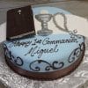The RC-072 is a round cake with blue and brown icing, topped with fondant Bible, chalice, and rosary decorations. "Happy 1st Communion Miguel" is written in black script on the cake.