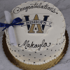 A round white cake (GC-001B Archbishop Williams High School) with scalloped edges, black dots, a “W Bishops” logo, blue-ribboned diploma, and “Congratulations Makayla” in black icing.
