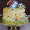 The BB-000D is a round cake with yellow icing, honey drip, buzzing bees, a fondant "Hunny" pot and flowers on top, plus Winnie the Pooh and Piglet artwork on the side. Served on a gold stand.