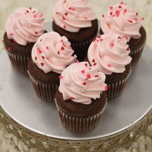 Six VC-040 Mini Display Valentine chocolate cupcakes with white chocolate mousse filling are arranged on a silver cake stand with an ornate edge.