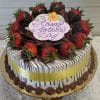 The MD-001 Display Strawberry Grand Marnier Cake is round, topped with chocolate-dipped strawberries, chocolate shavings, a yellow ribbon, chocolate drizzle, and an icing plaque that says "Happy Mothers Day" with a small yellow flower.