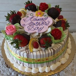 The MD-007 Lemon Raspberry Cake is a round Mother's Day cake topped with chocolate-dipped strawberries, pink and red roses, white chocolate shavings, and a pastel “Happy Mother’s Day” plaque, presented on a gold tray.