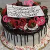 VC-009 is a round cake with white icing and chocolate drip, topped with strawberries, pink chocolate hearts, whipped cream, and a “Happy Birthday My Love” card. Pink sprinkles decorate the base.