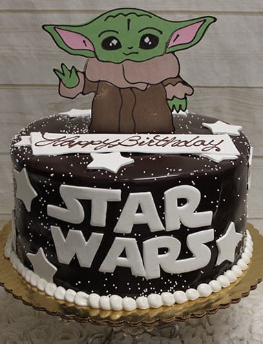 The CB-007D is a chocolate cake with white stars, STAR WARS lettering, a Baby Yoda cutout on top, and "Happy Birthday" written in white icing.