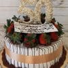 Introducing BD-000D: A white cake drizzled with chocolate, topped with chocolate-covered strawberries, a gold ribbon, a large "50" decor, and a cursive "Happy 50th Birthday" card on top.