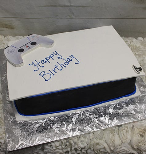 The CB-011L is a PlayStation 5 console-shaped birthday cake with a matching edible controller on top, “Happy Birthday” in blue icing, and sits on a silver decorative board.