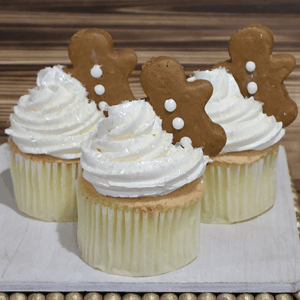 Three cupcakes filled with CH-062B Gold cupcake/chocolate filling, topped with white frosting and gingerbread man cookies, displayed on a white wooden tray with a beaded border.