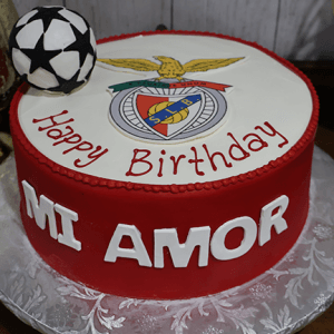 The ST-013 is a round birthday cake featuring a soccer ball, Benfica club logo, "Happy Birthday" on top, and "MI AMOR" in bold white letters on the red sides.