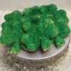 The STP-001A, a silver tray, holds shamrock-shaped cookies with green sugar sprinkles, displayed on a ruffled white cloth.
