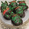 Five STP-020 St Patrick's Day Chocolate Dipped Strawberries, decorated with green icing and clover-shaped sprinkles, arranged on an ornate silver cake stand with beaded trim.