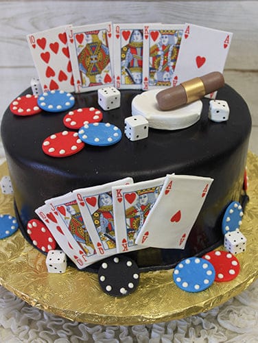 The GR-014 is a round black cake topped with fondant playing cards, poker chips, dice, and a small cigar, all arranged on and around the cake. It sits on a gold board.