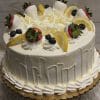 The BD-018B Lemon Blueberry Cake is a round cake with white frosting, lemon slices, white chocolate shavings, blueberries, and strawberries dipped in white chocolate on a gold cake board.