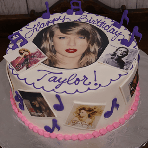 The BD-063 Taylor birthday cake features a woman’s face, album cover images, and purple musical notes. “Happy Birthday Taylor!” is written in purple icing on top.
