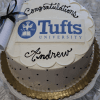 The GC-000N Tufts University cake features a white design with black polka dots, a gold base, a rolled diploma decoration, “Congratulations Andrew” written on it, and the Tufts University logo on top.