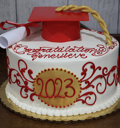 GC-015 is a round cake decorated with red and gold icing, featuring "2023" and "Congratulations Genevieve" on top, finished with a red graduation cap and diploma as toppers.