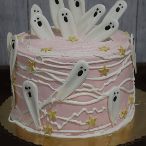 HW-000B is a pink frosted cake topped with white chocolate ghosts, white icing lines, yellow star decorations, and presented on a gold cake board.