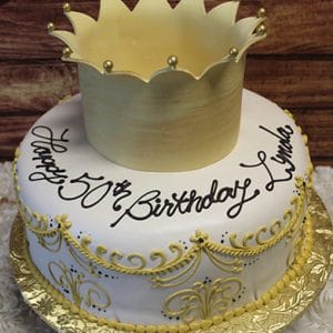 The BD-056B is a round white cake with gold accents, topped with a gold crown and “Happy 50th Birthday Linda” in black icing. It’s presented on a gold-patterned board.