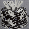 The HW-000A is a round chocolate cake topped with white icing ghosts, purple star shapes, and draped white icing lines for a spooky Halloween look.