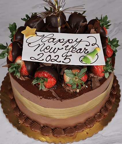 The NY-009 Tiramisu is a round chocolate cake topped with strawberries, chocolate-dipped strawberries, chocolate pieces, and a gold ribbon. A white plaque reads “Happy New Year 2025” with a star and champagne bottle illustration.