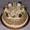 The BD-008B Carrot is a round cake topped with white chocolate shavings, carrots, and strawberries dipped in white chocolate. The sides are covered in chopped nuts and there's piped cream around the base.