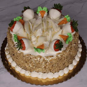 The BD-008B Carrot is a round cake topped with white chocolate shavings, carrots, and strawberries dipped in white chocolate. The sides are covered in chopped nuts and there's piped cream around the base.
