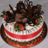 The BD-000B Strawberry Grand Marnier is a decorated cake with white frosting, chocolate drizzle, shavings, heart shapes, dipped strawberries, colorful sprinkles, a red ribbon, and piped chocolate on a gold tray.
