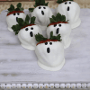 Six strawberries dipped in white chocolate, decorated as ghosts with chocolate faces and leafy tops, are arranged on a white wooden tray with a beaded edge. Product: HW-020.