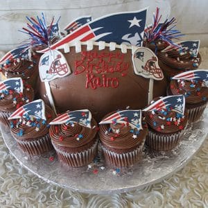 ST-002C Strawberry Grand Marnier cake, decorated with the New England Patriots logo, edible helmet toppers, red and blue star sprinkles, and “Happy Birthday Kairo” written in red icing.