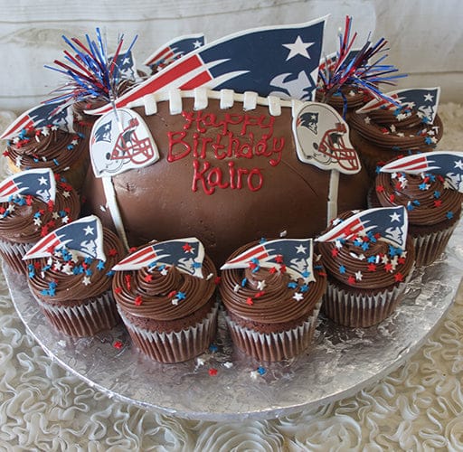 ST-002C Strawberry Grand Marnier cake, decorated with the New England Patriots logo, edible helmet toppers, red and blue star sprinkles, and “Happy Birthday Kairo” written in red icing.