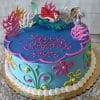 The SC-016A Little Mermaid cake is blue, decorated with colorful seaweed, shells, flowers, and topped with an Ariel figure. “Happy Birthday Joyce” is written in pink icing.