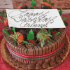 The CH-002 Display Chocolate mousse cake features chocolate-covered strawberries, holly leaves, red berries, and a red-striped ribbon. A white card on top says "Happy Birthday Arlene" in cursive chocolate writing.
