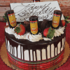 The CH-011 Display Marble Kahlua with Christmas Decor features a marble cake drizzled with chocolate, topped with strawberries, whipped cream, four mini Kahlúa bottles, a plaid ribbon, and a "Happy Birthday" white chocolate plaque.