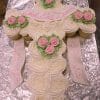 The RC-110 is a cross-shaped cake made of white frosted cupcakes, decorated with pink and green flowers and a white ribbon with “God Bless Lauren” in pink icing, displayed on a silver foil-covered tray.