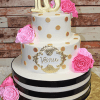 The TC-016 cake features two white tiers with gold polka dots, black stripes on the bottom tier, pink sugar roses, a gold "16" topper, and a name plaque reading "Veeru," all on a gold cake board.