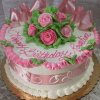 The AN-008 is a round birthday cake with a white base, pink roses, green leaves, pink ribbon-like icing, and "Happy Birthday, Roseline" in pink frosting. It sits on a gold board.