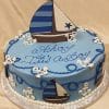BB-039: Round blue cake with sailboats, white anchors, and blue piping. Topped with a large sailboat and "Ahoy, Its A Boy" written in blue icing.
