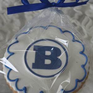 The GC-080H Braintree High School is a round iced cookie with a large blue "B" and blue edging, wrapped in clear plastic with a blue ribbon.