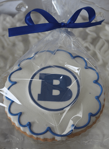 The GC-080H Braintree High School is a round iced cookie with a large blue "B" and blue edging, wrapped in clear plastic with a blue ribbon.