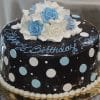 The BD-078 is a round chocolate cake decorated with white and light blue polka dots, topped with white and blue icing roses, and features "Happy Birthday" written in blue icing on top.