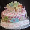 The BB-032 is a round white cake with pink polka dots, pastel animal-shaped cookies, and "It's a Girl" on top. A plaque at the base says "Congratulations Fasie & Eden" in pink script.